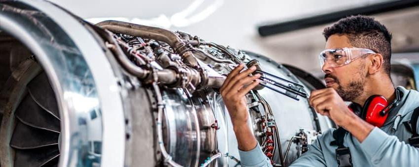 An Aviation Maintenance student works on an engine.